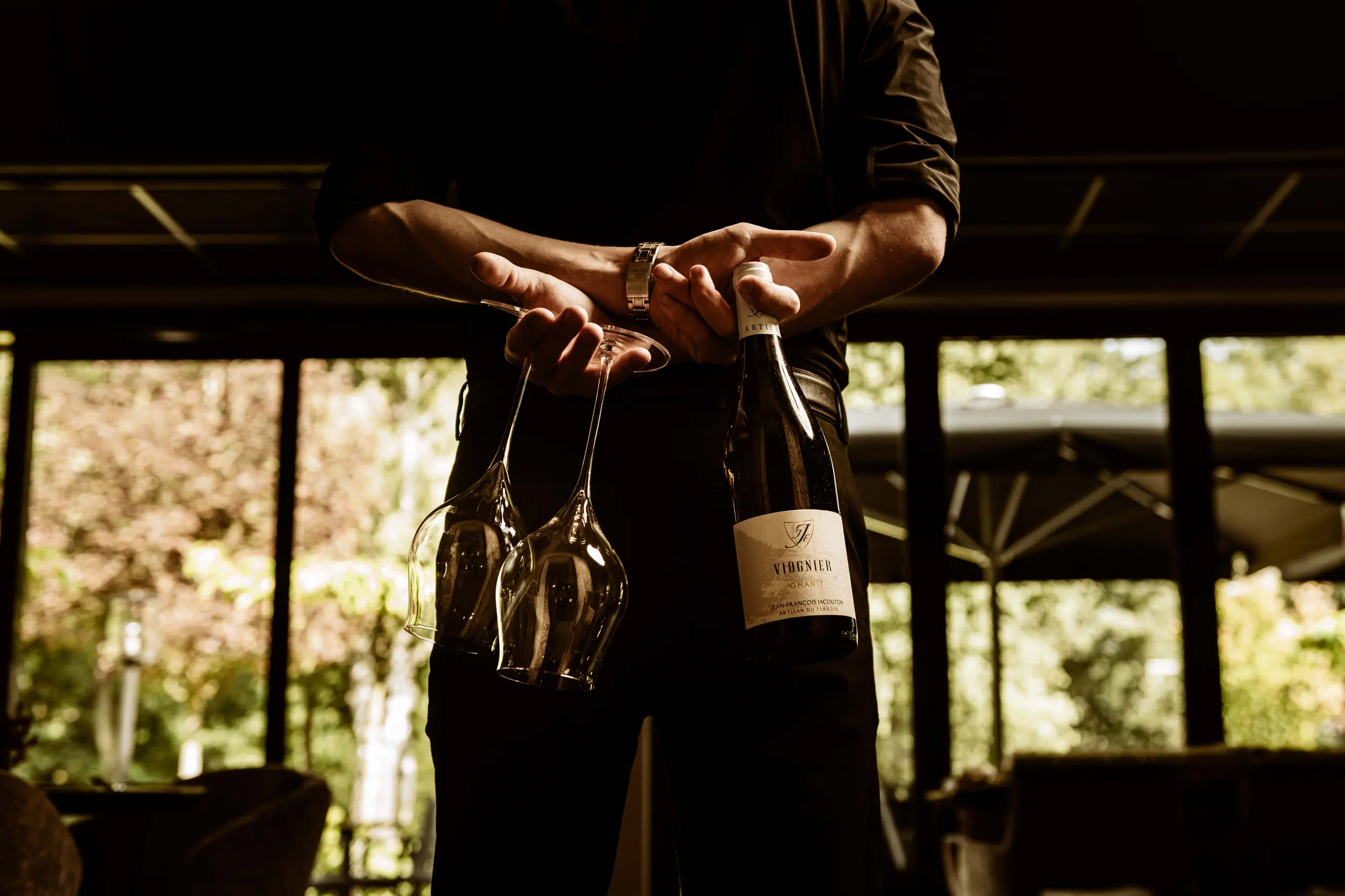 Der Gastgeber schenkt ein Glas Wein ein