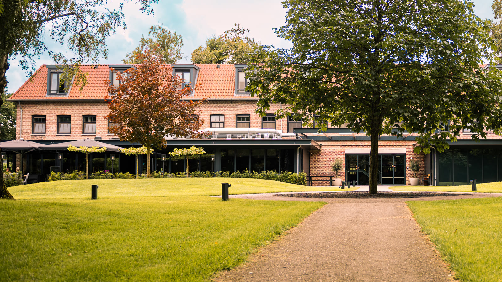 De Kastanjefabriek heute, restauriert, mit dem Rasen und dem Baum davor
